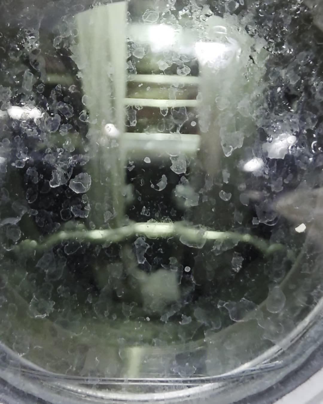 Fabric visible through a dye machine porthole